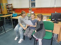 Trzy dziewczynki odczytują swoje wyniki prac