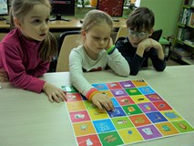 Troje dzieci gra w grę planszową