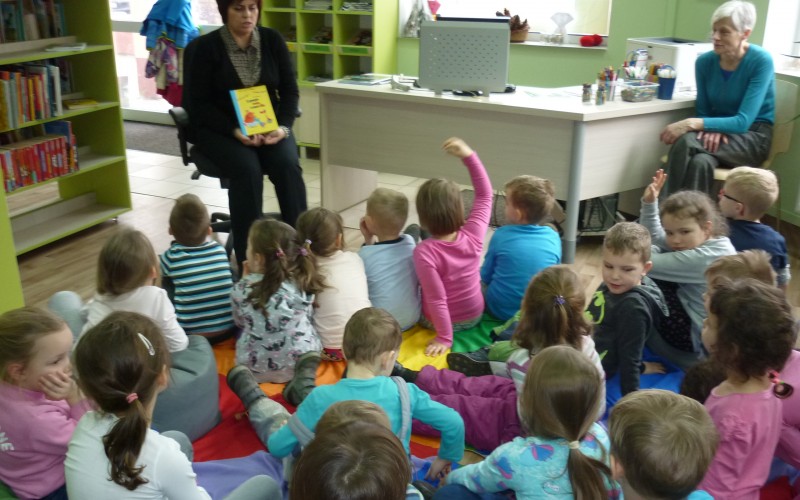 Bibliotekarka prezentuje dzieciom książkę