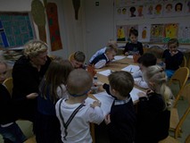 Przedszkolaki siedzą przy stołach i malują jak wygląda Wiosna.