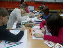 Dzieci wykonują pracę plastyczną przy stole