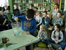 dziecko miesza tajemniczą miksturę w szklanym naczyniu