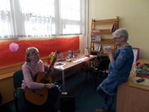 Pani grająca na gitarze rozmawia z drugą panią