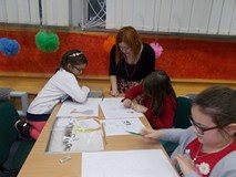 Bibliotekarka pomaga dziewczynce w pracy plastycznej