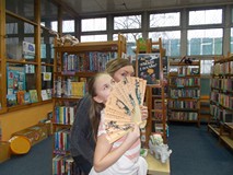 Bibliotekarka pozuje z dziewczynką trzymającą wachlarz