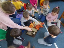 Bibliotekarka wraz z dziećmi ogląda przestrzenną książkę