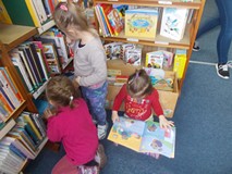 Troje dzieci ogląda ksiązki