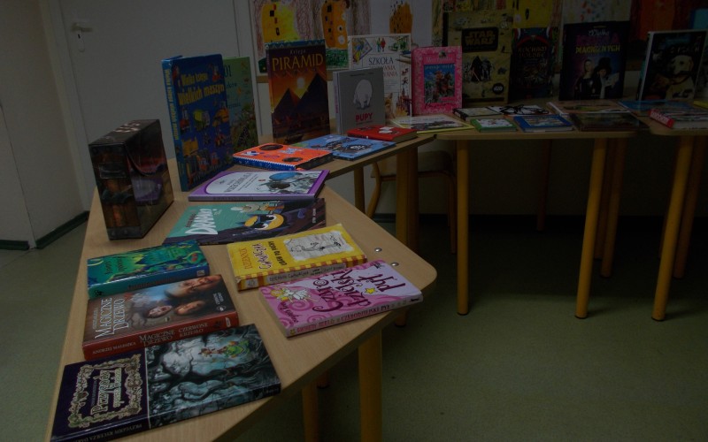 Wystawa książek dla dzieci i młodzieży. Książki rozłożone są na stolikach.