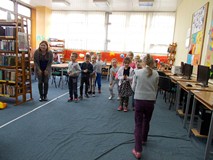 Przedszkolaki stoją w dwóch rzędach i niosą jajko na paletce