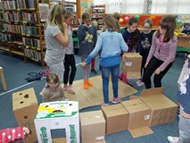 Dzieci wspólnie budują wieżę z kartonów