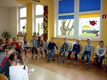 Dzieci w skupieniu słuchają Pani Wioli prezentującej książki o różnych zawodach