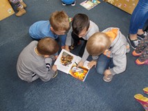 Czterech chłopców ogląda ksiązeczkę