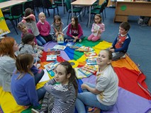 Dzieci siedzą na chuście animacyjnej