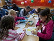 Dzieci malują prace przy stolikach