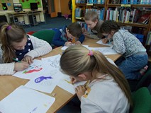 Dzieci malują kredkami przy stoliku