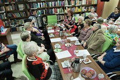 Występ dla seniorów z Bibliotece w Polanowie. Na zdjęciu akordeonista i duża  grupa seniorów przy st