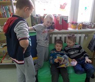 Chłopcy przy oknie zainteresowani czasopismami