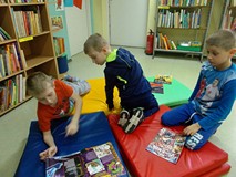 Materace rozłożone na podłodze. Chlopcy oglądają wybrane czasopisma