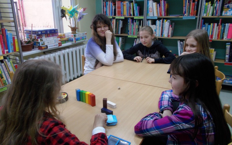 Dziewczynki przy stoliku z jedną z gier