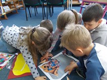 Dzieci układaja puzzle w drużynie