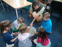 Leśniczy pomaga dzieciom odciskać tropy leśnych zwierząt