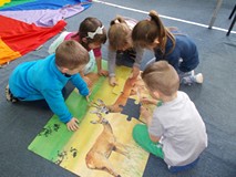 Dzieci układają wspólnie puzzle