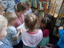 Bibliotekarka czyta z dziećmi książkę