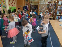 Dzieci stoją w grupie z ilustracjami w ręku