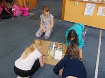 Dzieci w grupie zapisują odpowiedzi na szarym papierze