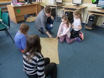 Bibliotekarka ocenia pracę grupy, która zapisywała odpowiedzi na kartce