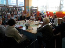 Goście siedzą przy stole i dyskutują o książce