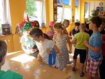 Dzieci stoją przy stolikach - układają ALFABETYCZNE PUZZLE