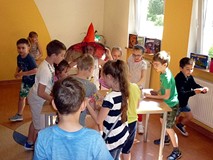 Dzieci stoją przy stolikach - układają ALFABETYCZNE PUZZLE