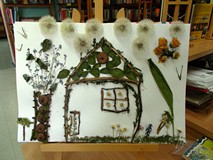 Domek, drzewko i chmury przyklejone do kartki papieru. Dzieci stworzyły roślinny obraz