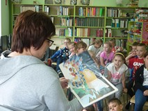 Bibliotekarka i dzieci słuchające opowieści o Arturze