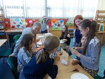 Dzieci przy stołach wykonują prace plastyczne