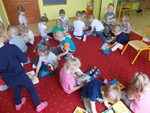 Dzieci oglądają książki i bawią się pacynkami