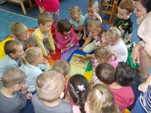 Dzieci oglądają książkę wraz z leśniczyną