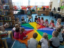 Leśniczyna pokazuje dzieciom książkę Basia w lesie