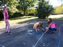 Dzieci tworzą kredowe rysunki