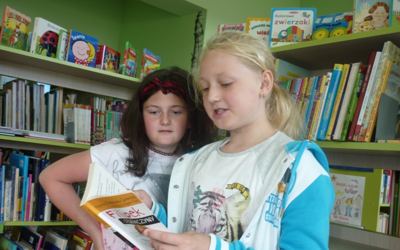 Dziewczynki czytają książkę pod tytułem 