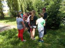 Dzieciaki przyglądają się drzewom  w ogrodzie