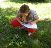 Dziewczynka przygląda sie uważnie rosnącym roślinom