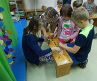 Grupa dzieci pracuje nad prawidłowymi nazwami owoców drzew