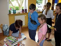 Małgorzata Strękowska-Zaremba rozdaje autografy po spotkaniu w bibliotece