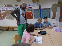 Dzieci siedzą przy stole, oglądają książki o ptakach