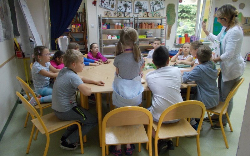 Pani bibliotekarka wyjaśnia dzieciom na czym polega robienie zielnika