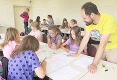 Dzieci i młodzież biorąca udział w warsztatach graficznych z Arturem Wabikiem