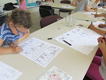 Dzieci i młodzież biorąca udział w warsztatach graficznych z Arturem Wabikiem