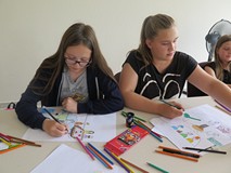 Dzieci i młodzież biorąca udział w warsztatach graficznych z Arturem Wabikiem